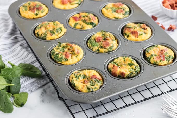 Spinach and cheese egg muffins in a muffin pan.