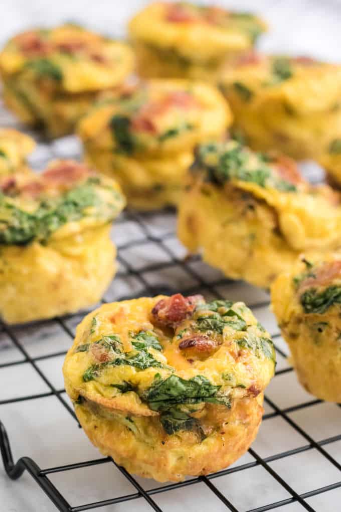 Spinach and cheese egg muffins on a wire rack.