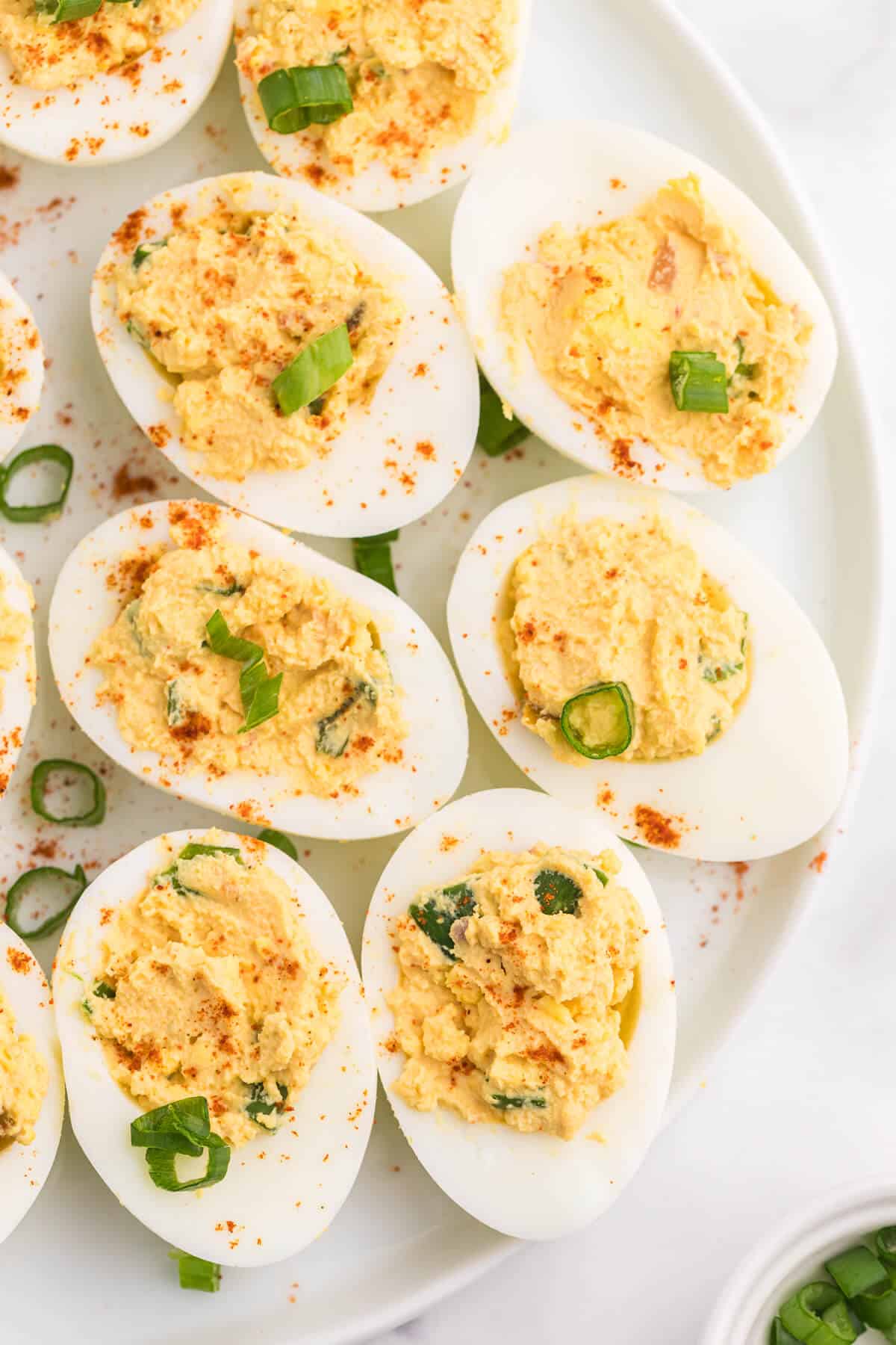 overhead photo of salsa deviled eggs on a white plate.