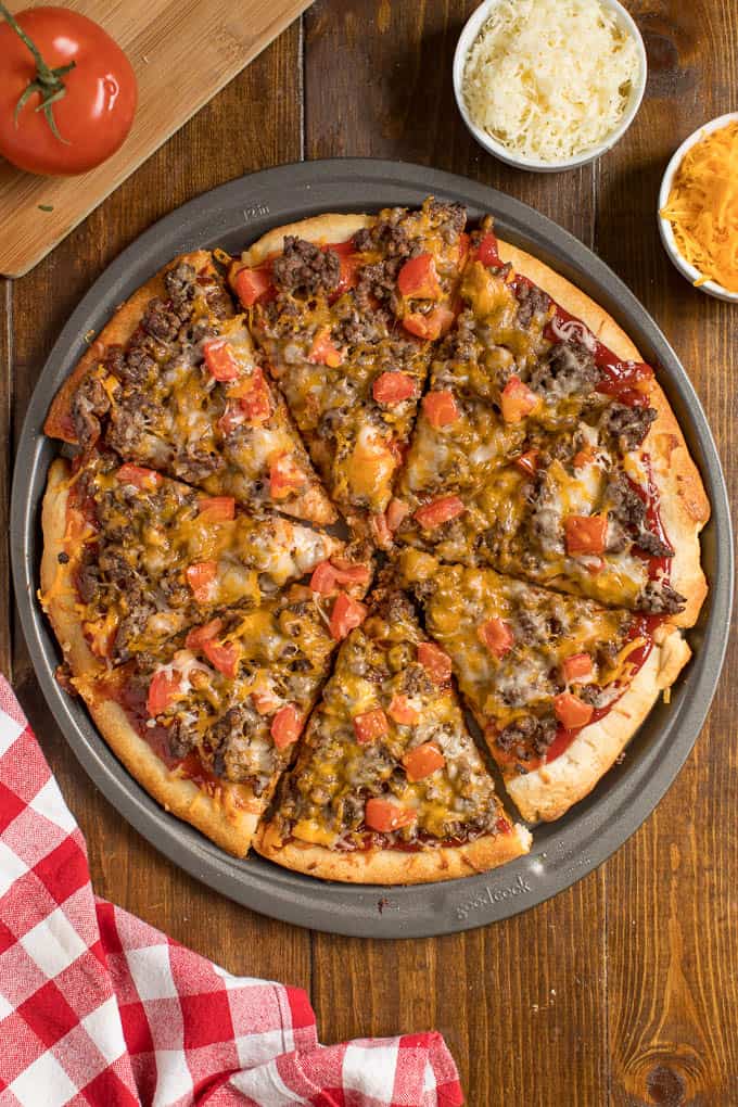 Cheeseburger pizza on a pizza pan.