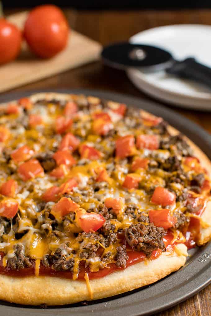 Cheeseburger pizza on a pizza pan.