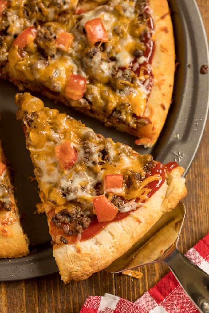 Slices of cheeseburger pizza on a pizza pan.