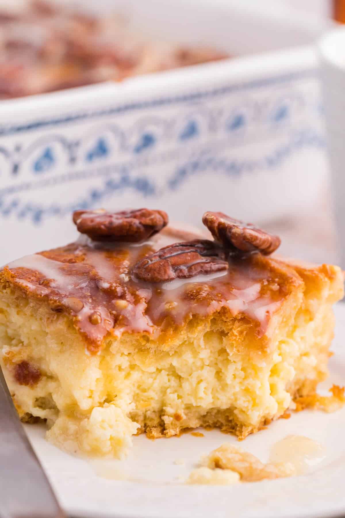 A piece of maple pecan danish bake on a plate with a bite out of it.