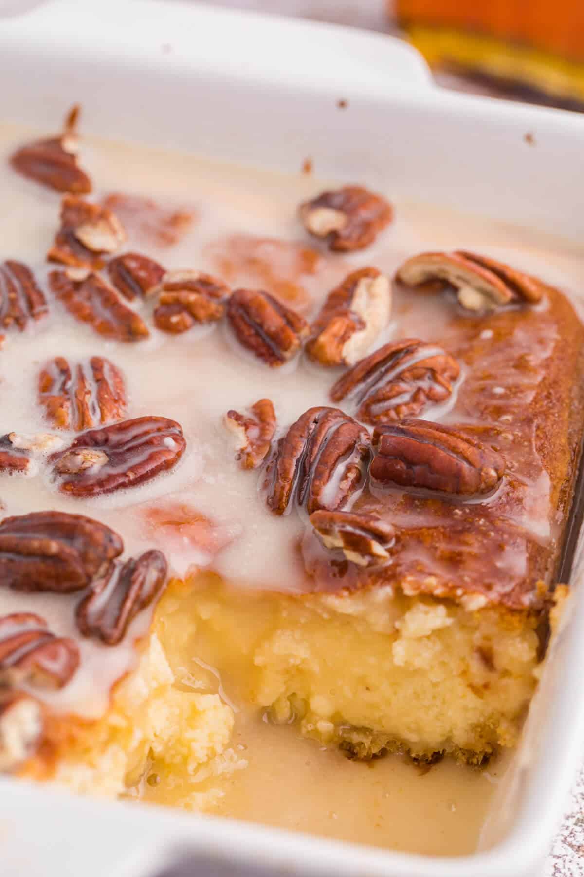 Maple pecan danish bake in a casserole dish with a piece cut out.