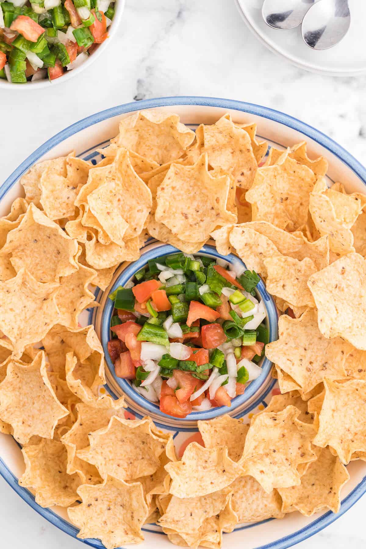 A platter of tortilla chips with pico de gallo.