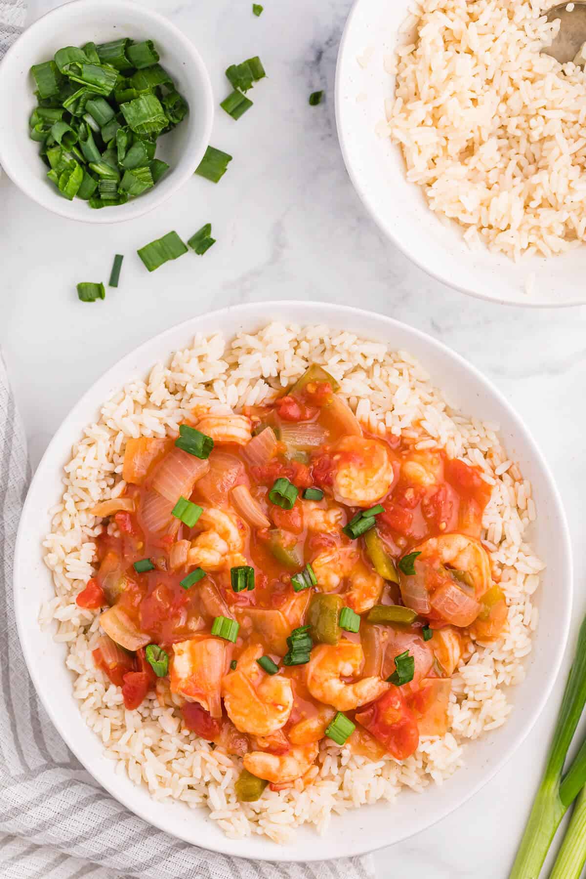 Shrimp creole over a bed rice in a bowl.