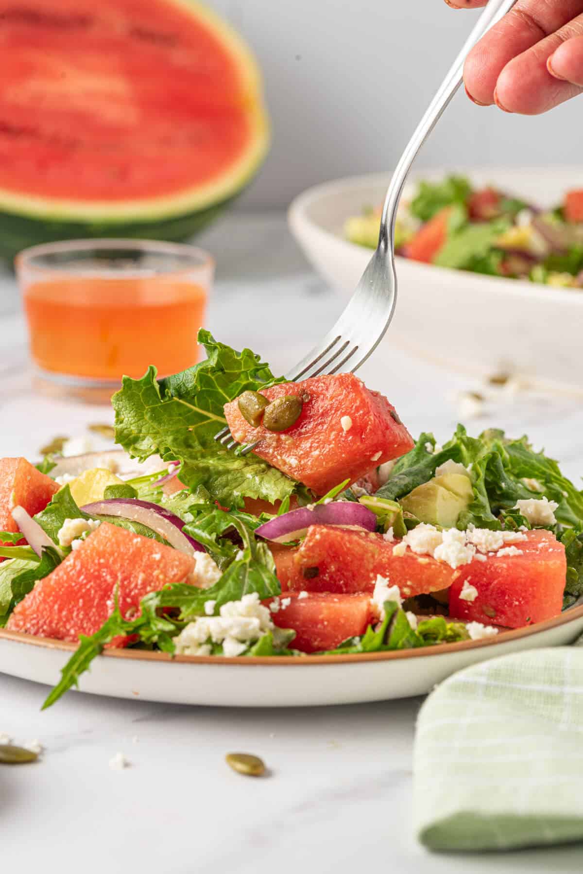 A fork with a piece of Watermelon and Feta Salad on it.