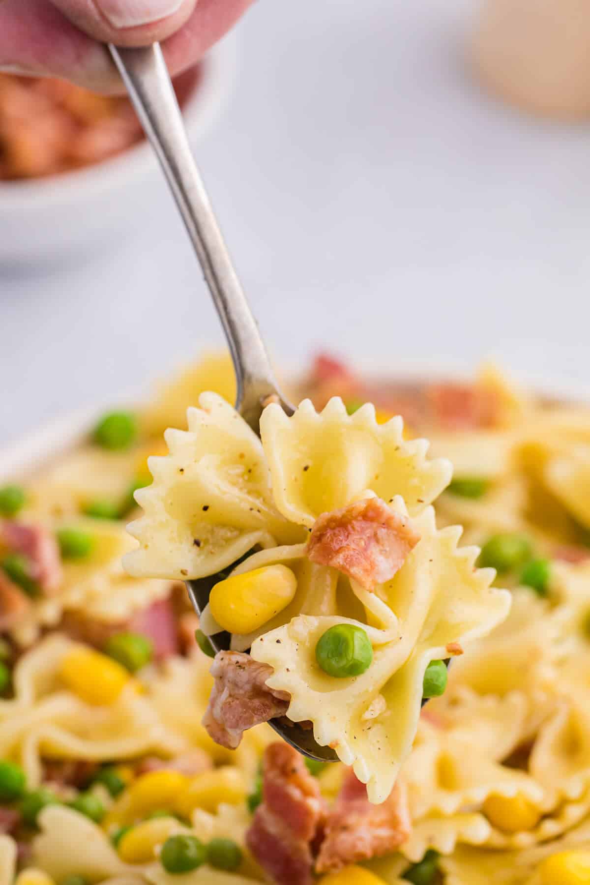 A spoonful of bacon pea pasta salad.