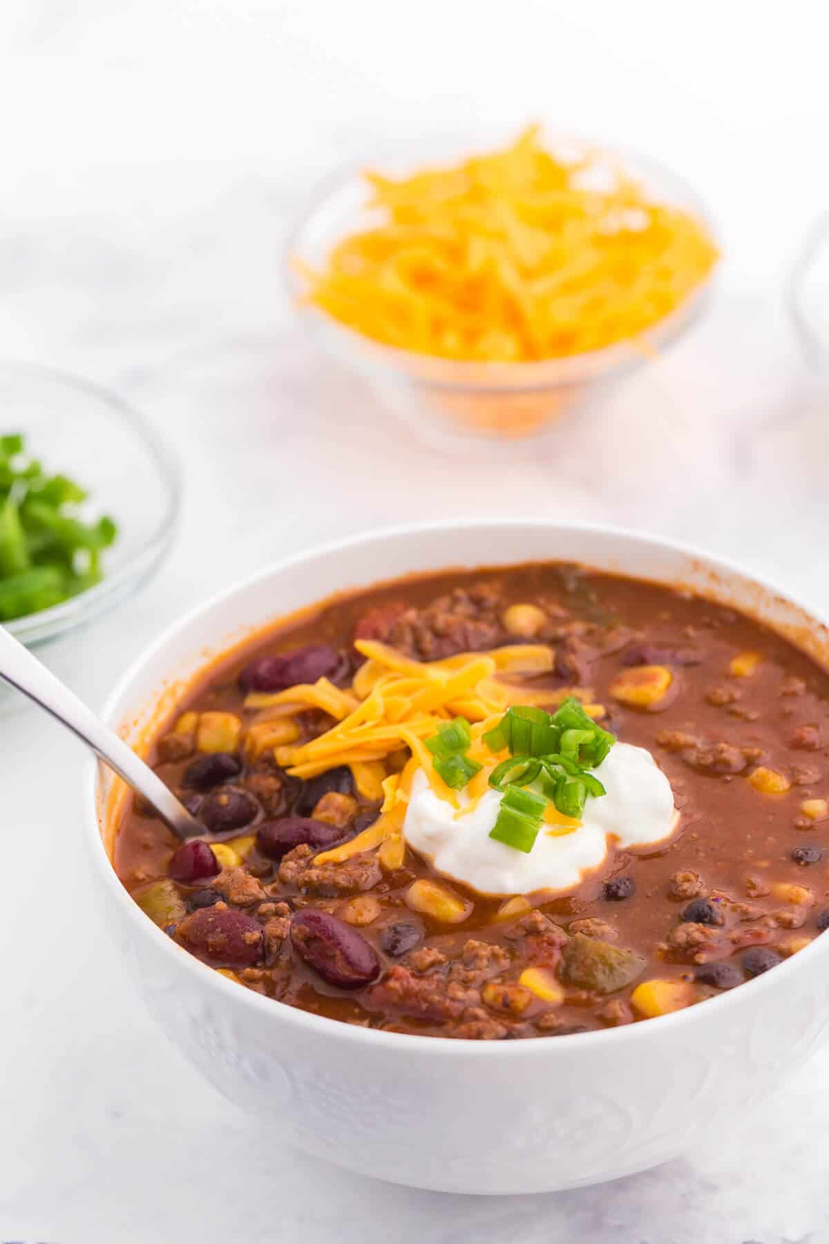 Pantry Chili - A simple, hearty soup made with just pantry staples! This beefy chili recipe is packed with corn, black beans, tomatoes, and kidney beans with a homemade seasoning blend for the best homemade chili recipe.