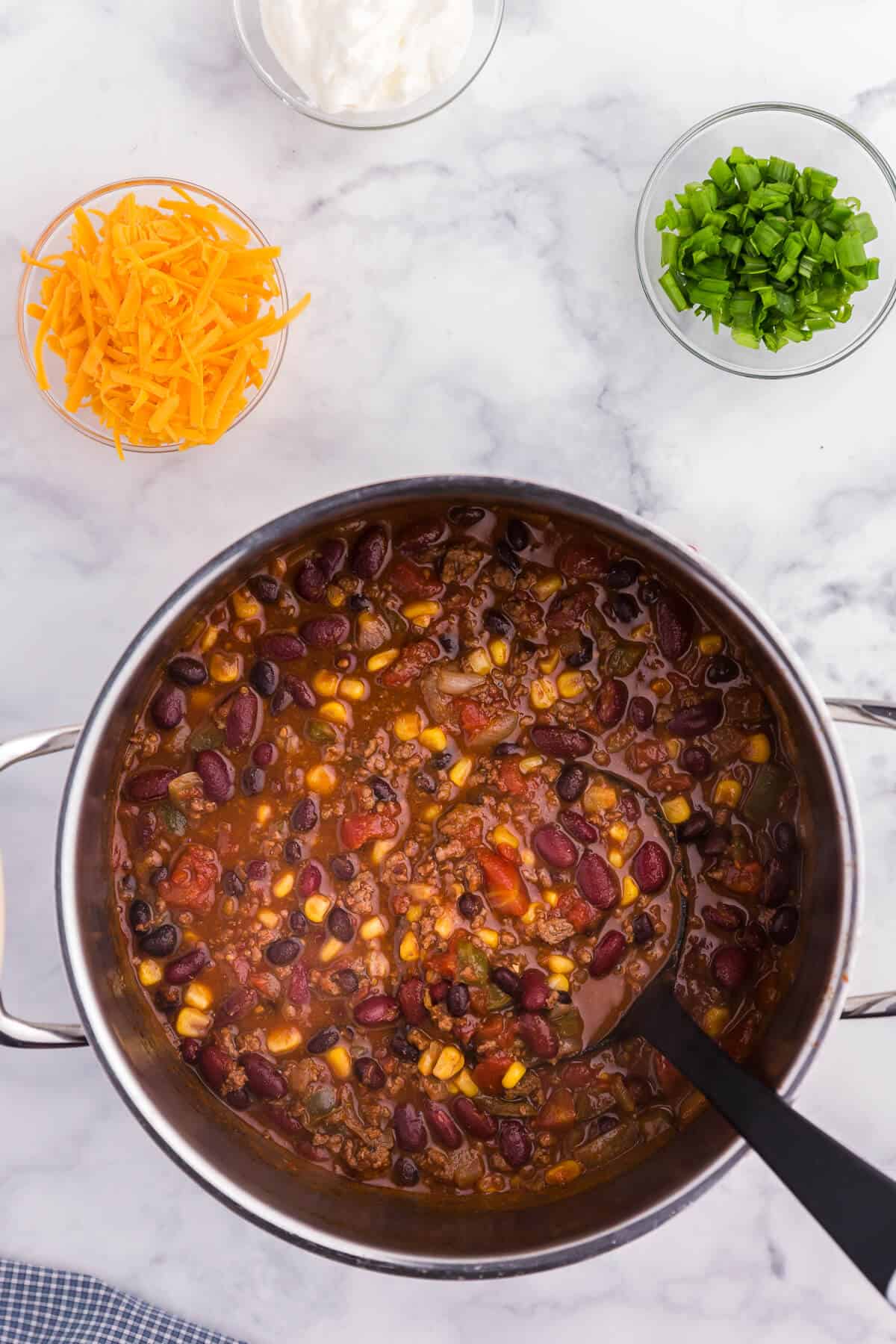 Pantry Chili - A simple, hearty soup made with just pantry staples! This beefy chili recipe is packed with corn, black beans, tomatoes, and kidney beans with a homemade seasoning blend for the best homemade chili recipe.
