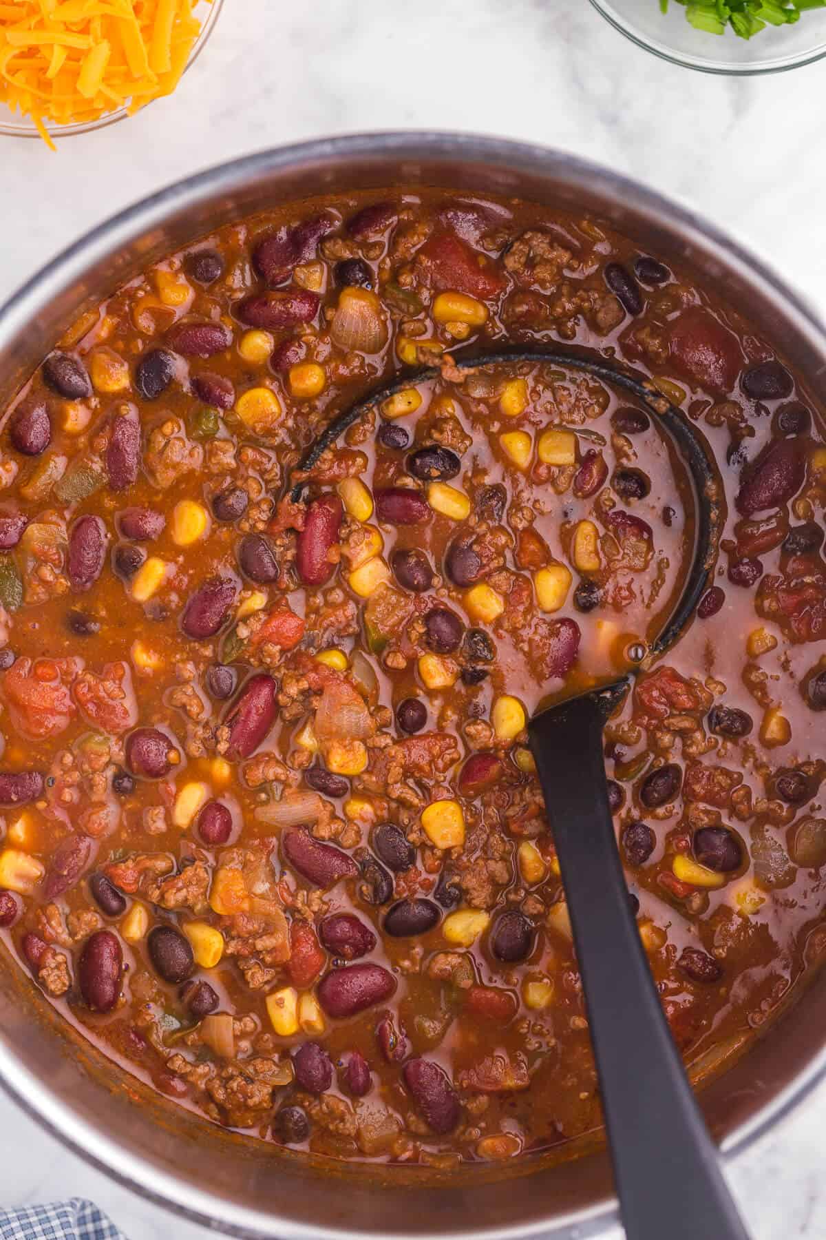 Pantry Chili - A simple, hearty soup made with just pantry staples! This beefy chili recipe is packed with corn, black beans, tomatoes, and kidney beans with a homemade seasoning blend for the best homemade chili recipe.