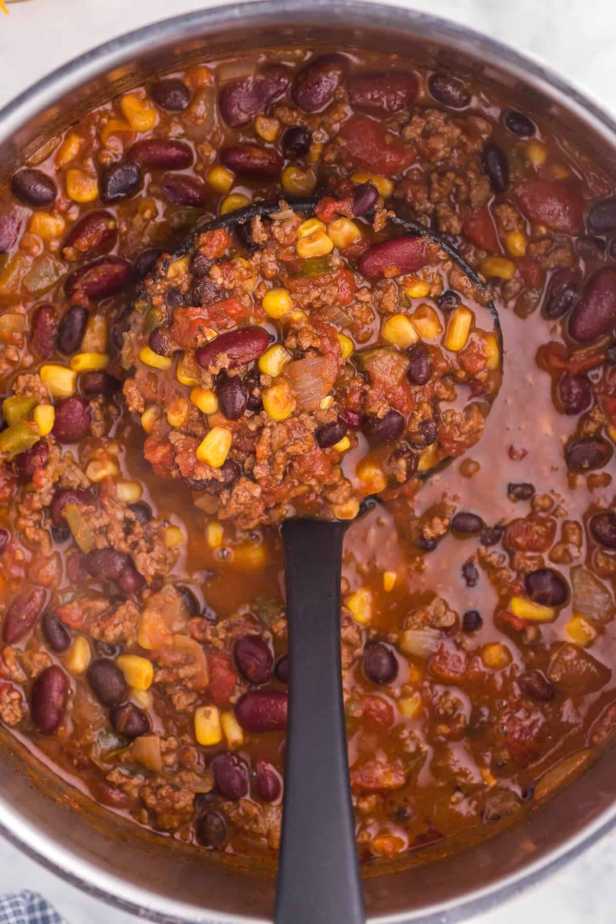 Pantry Chili - A simple, hearty soup made with just pantry staples! This beefy chili recipe is packed with corn, black beans, tomatoes, and kidney beans with a homemade seasoning blend for the best homemade chili recipe.