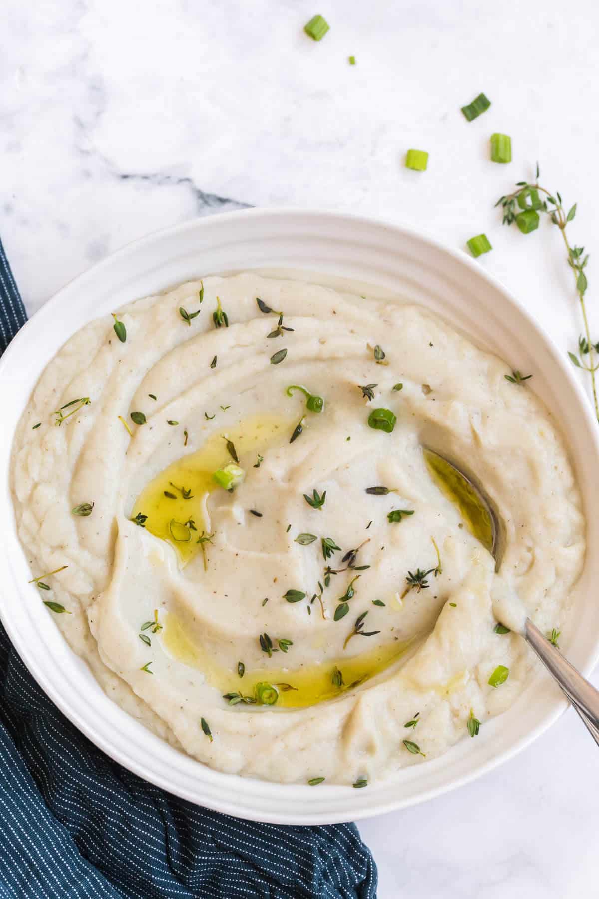 Mashed cauliflower in a bowl with a spoon.