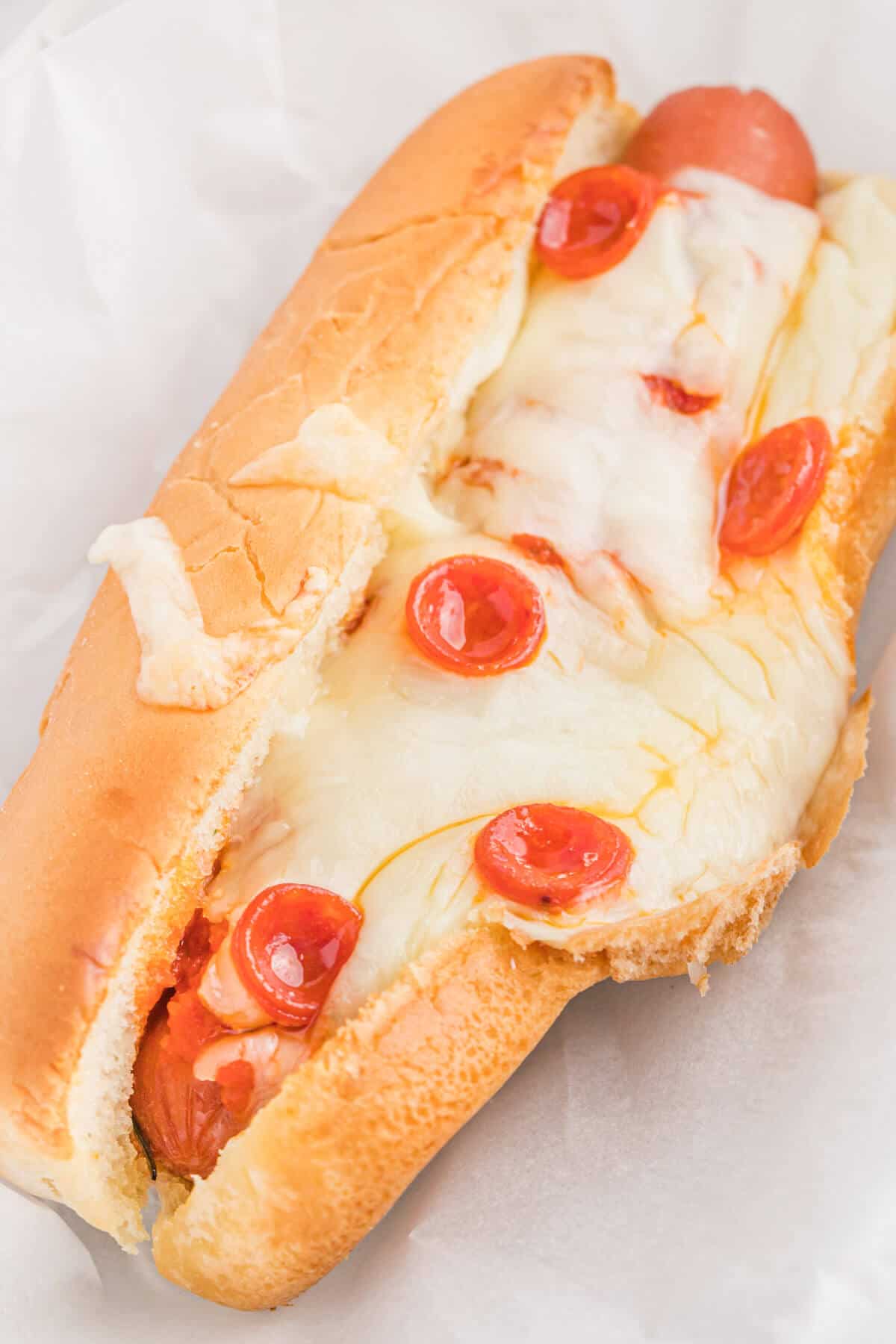 A pizza hot dog on a plate.