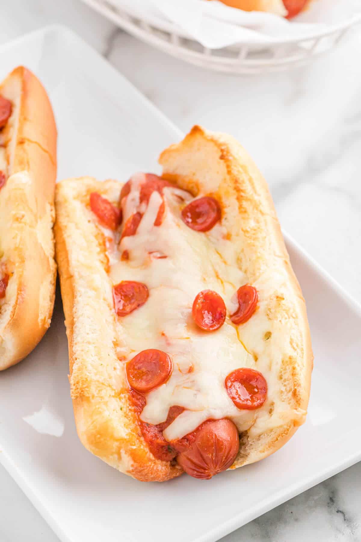 Pizza Hot dogs on a white platter.