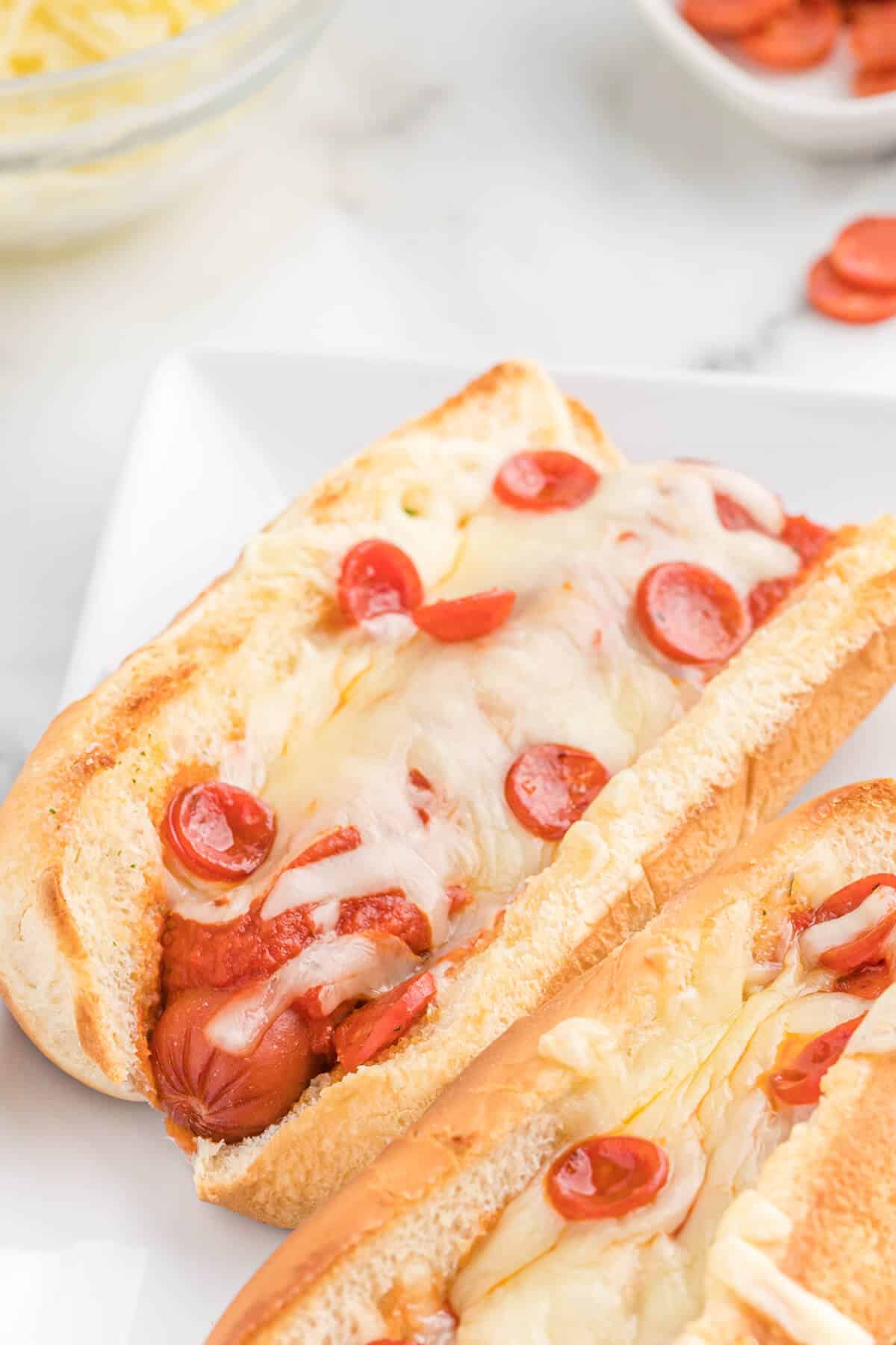 Pizza Hot dogs on a white platter.