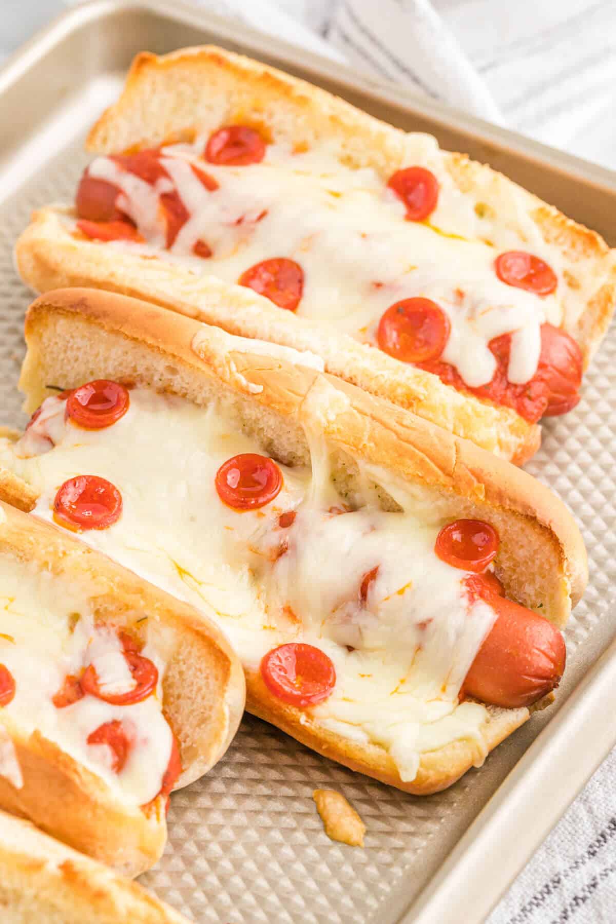 Pizza hot dogs on a baking sheet.