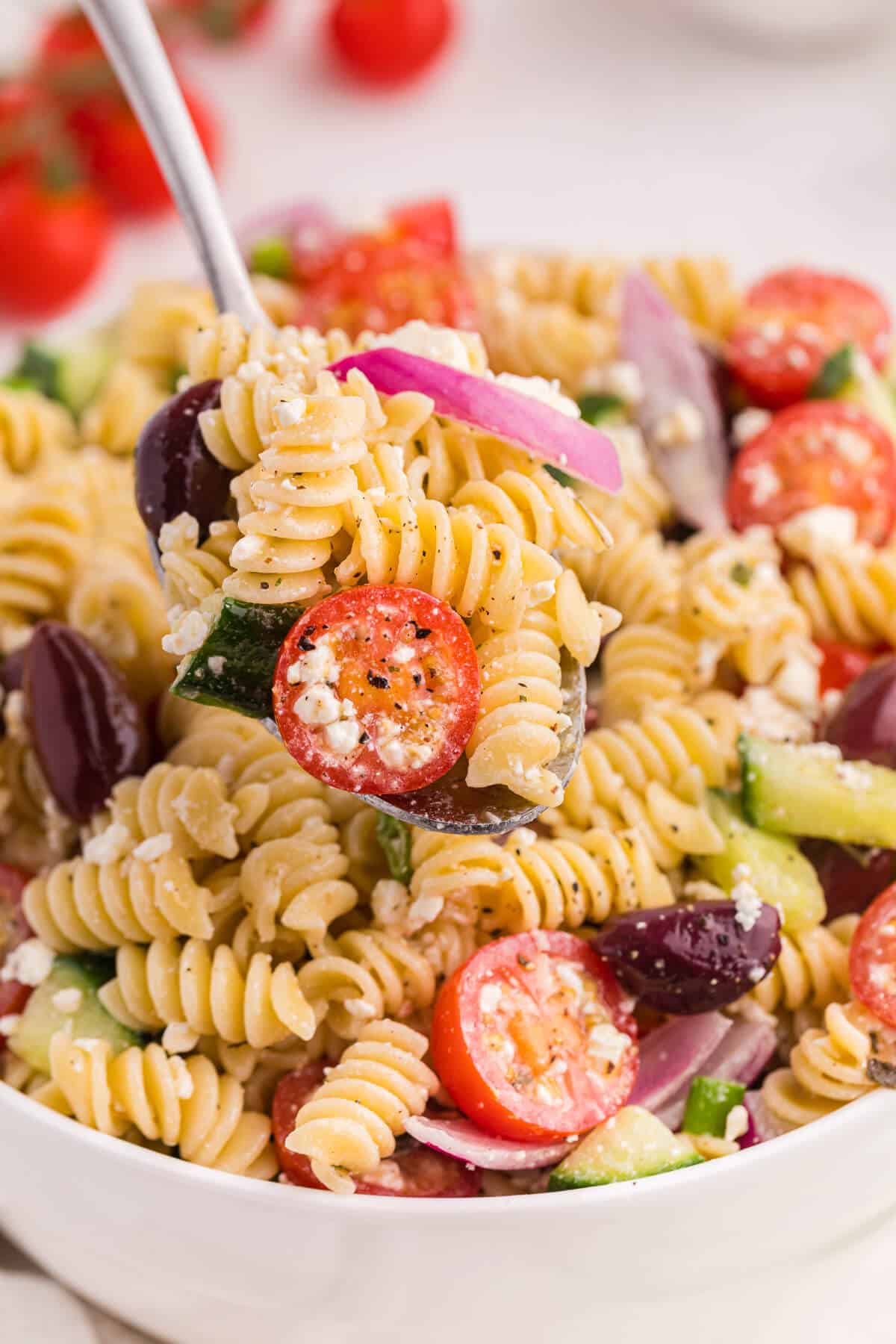 Greek pasta salad on a serving spoon.