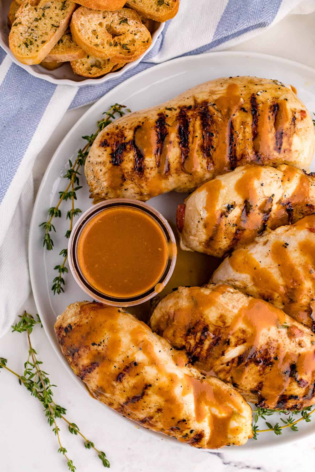 Grilled herb chicken on a plate with sauce.