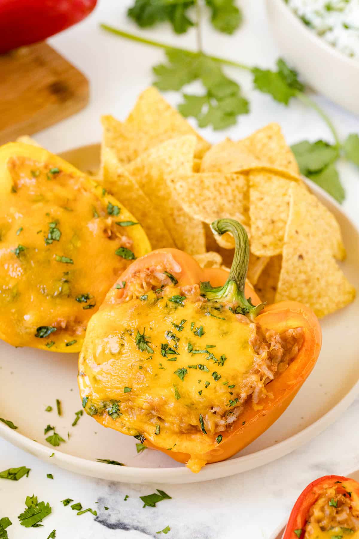 The peppers on a plate with tortilla chips.