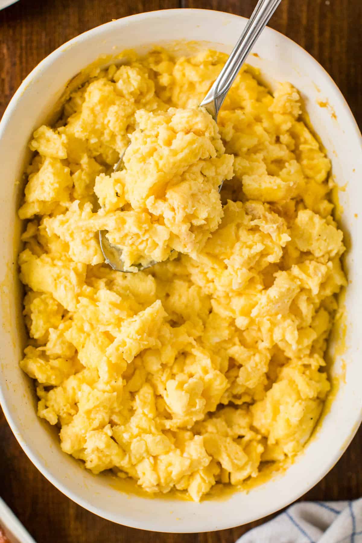 Oven scrambled eggs in a casserole dish with a serving spoon.