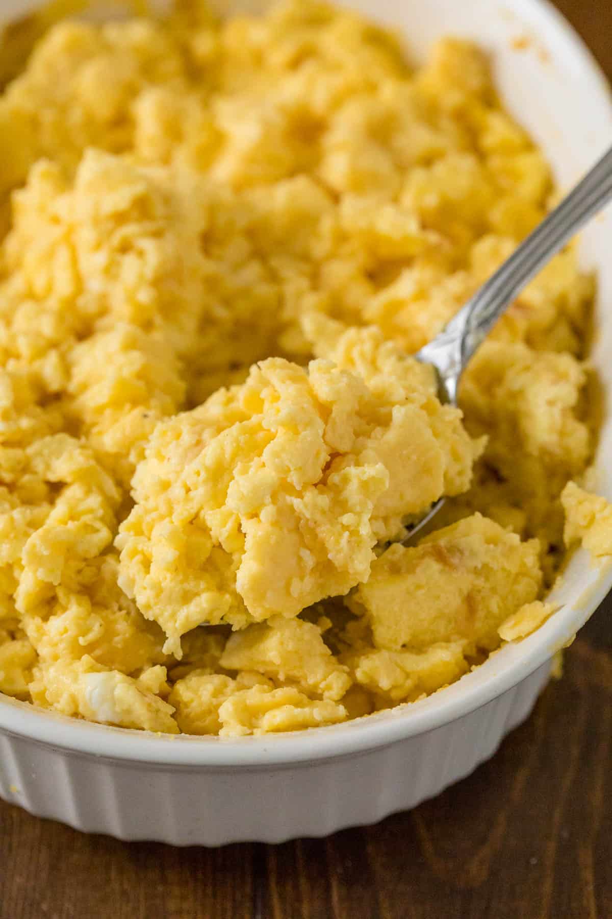 photo of scrambled eggs in a casserole dish with a serving spoon.