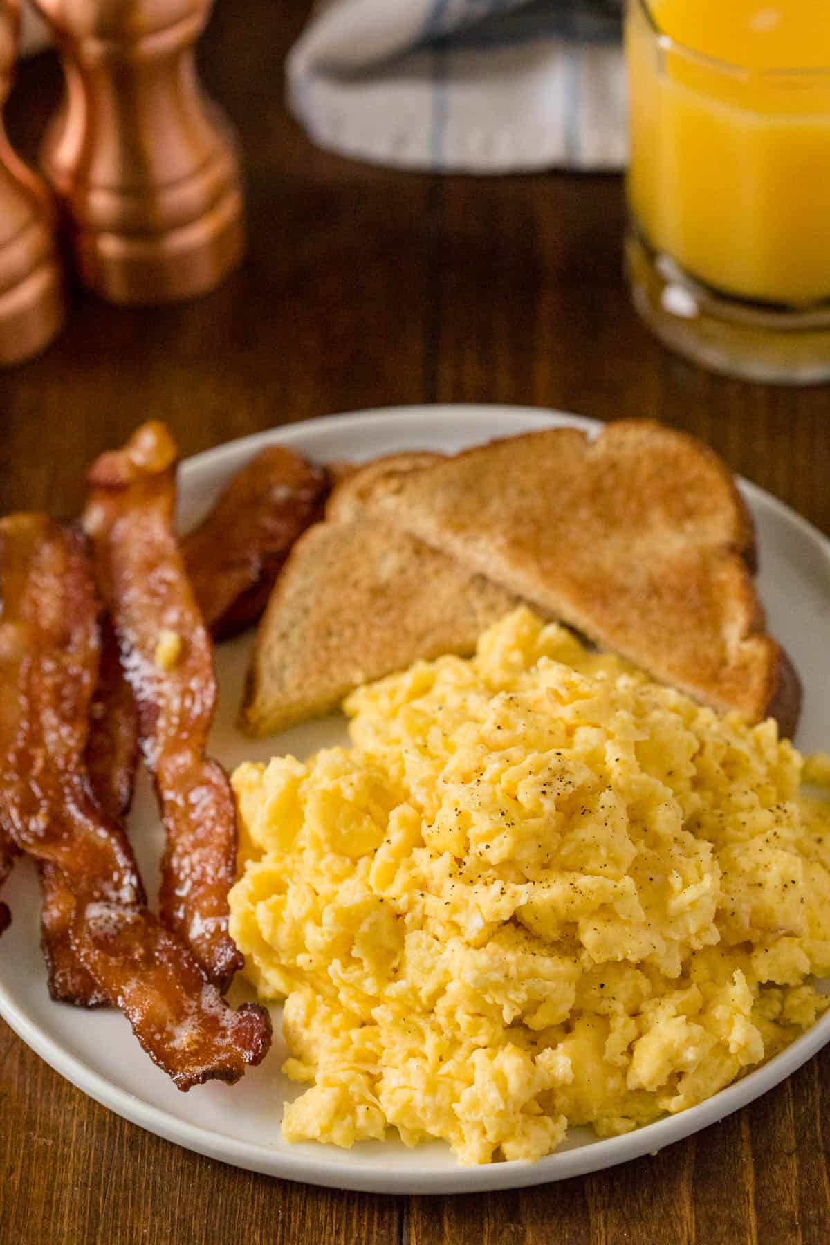 Oven scrambled eggs on a plate with bacon and toast.