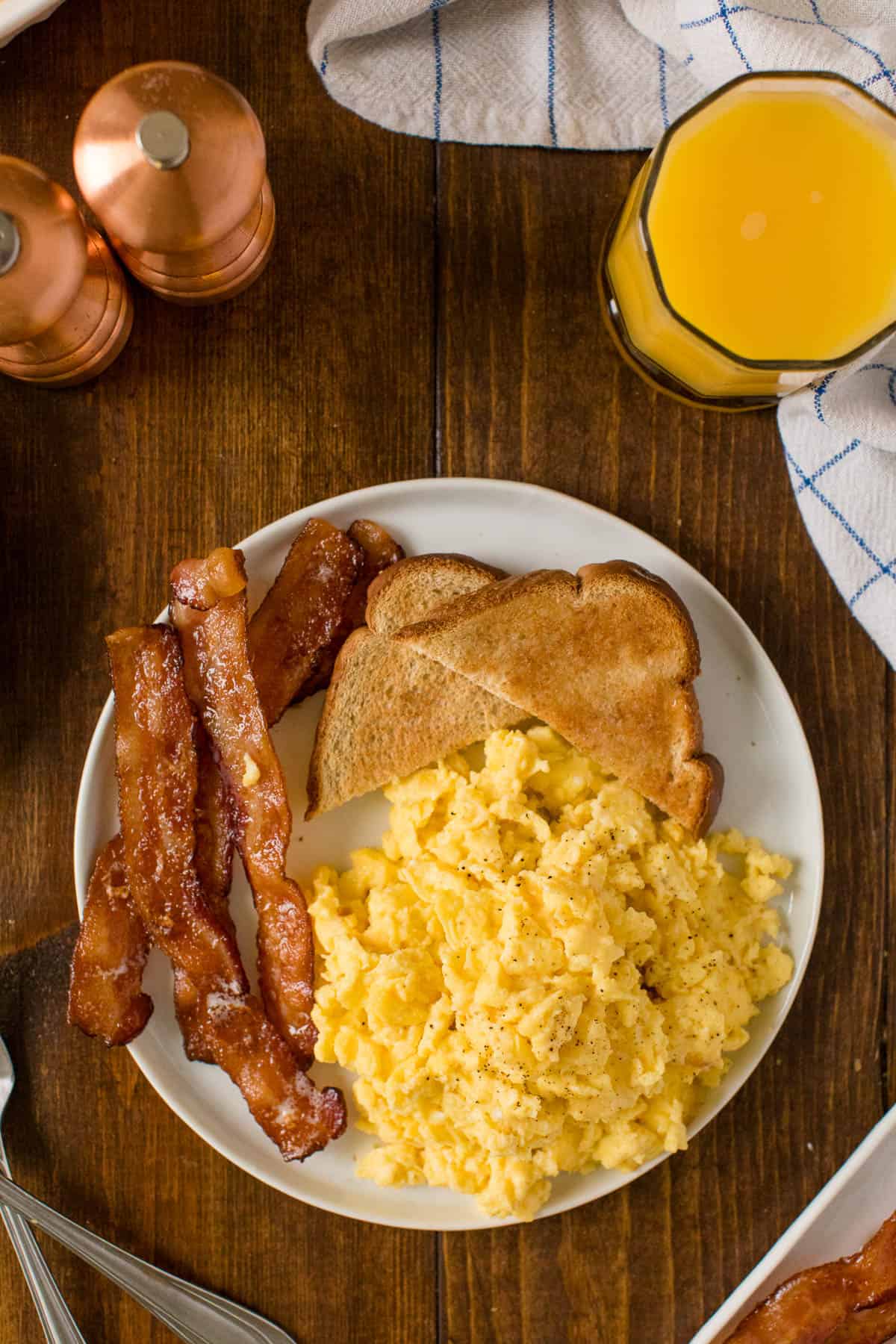 Oven scrambled eggs on a plate with bacon and toast.