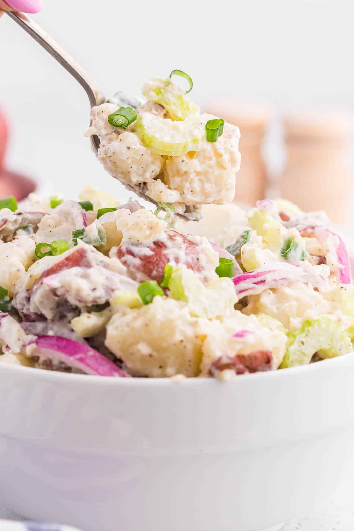 Ranch potato salad on a serving spoon.