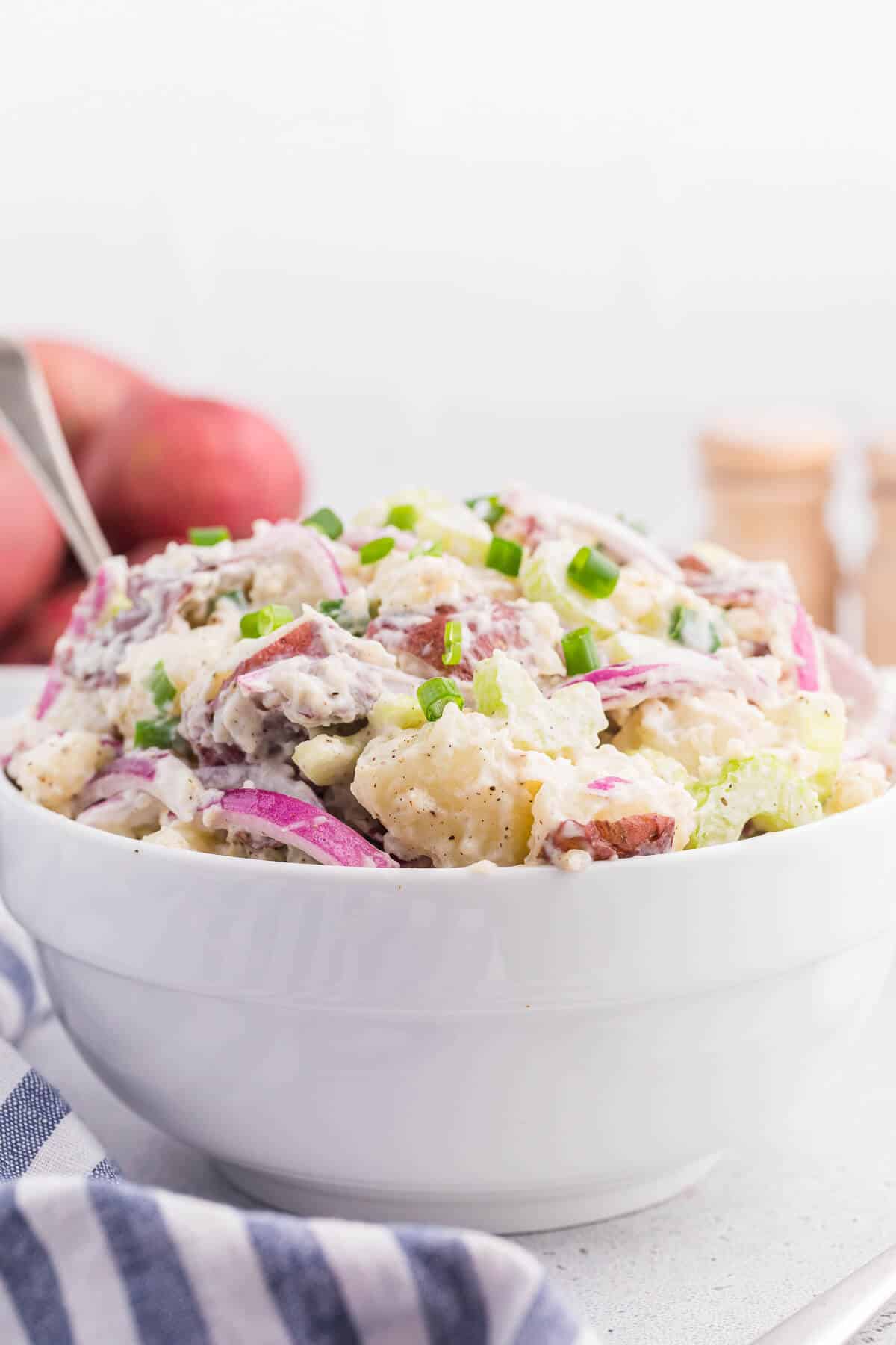 Ranch potato salad in a bowl with a spoon.