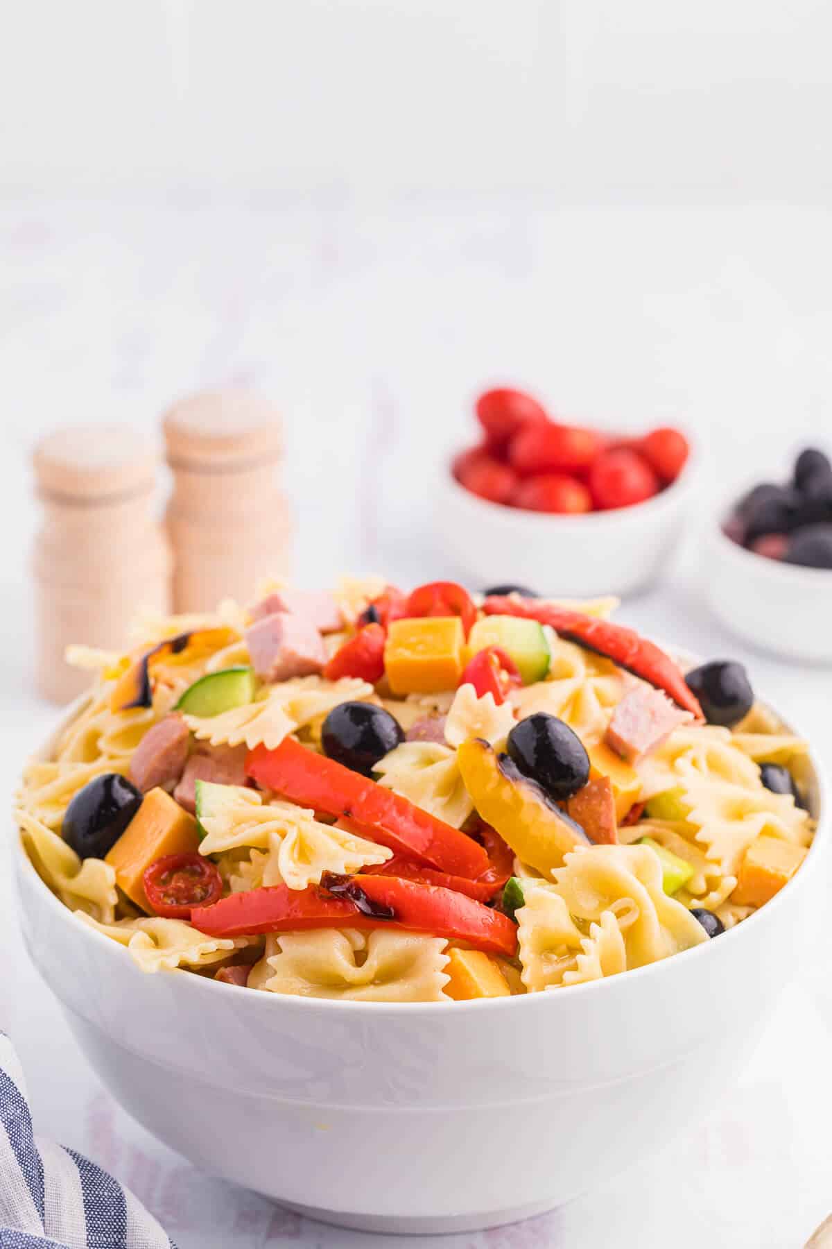 A white bowl of roasted pepper pasta salad.