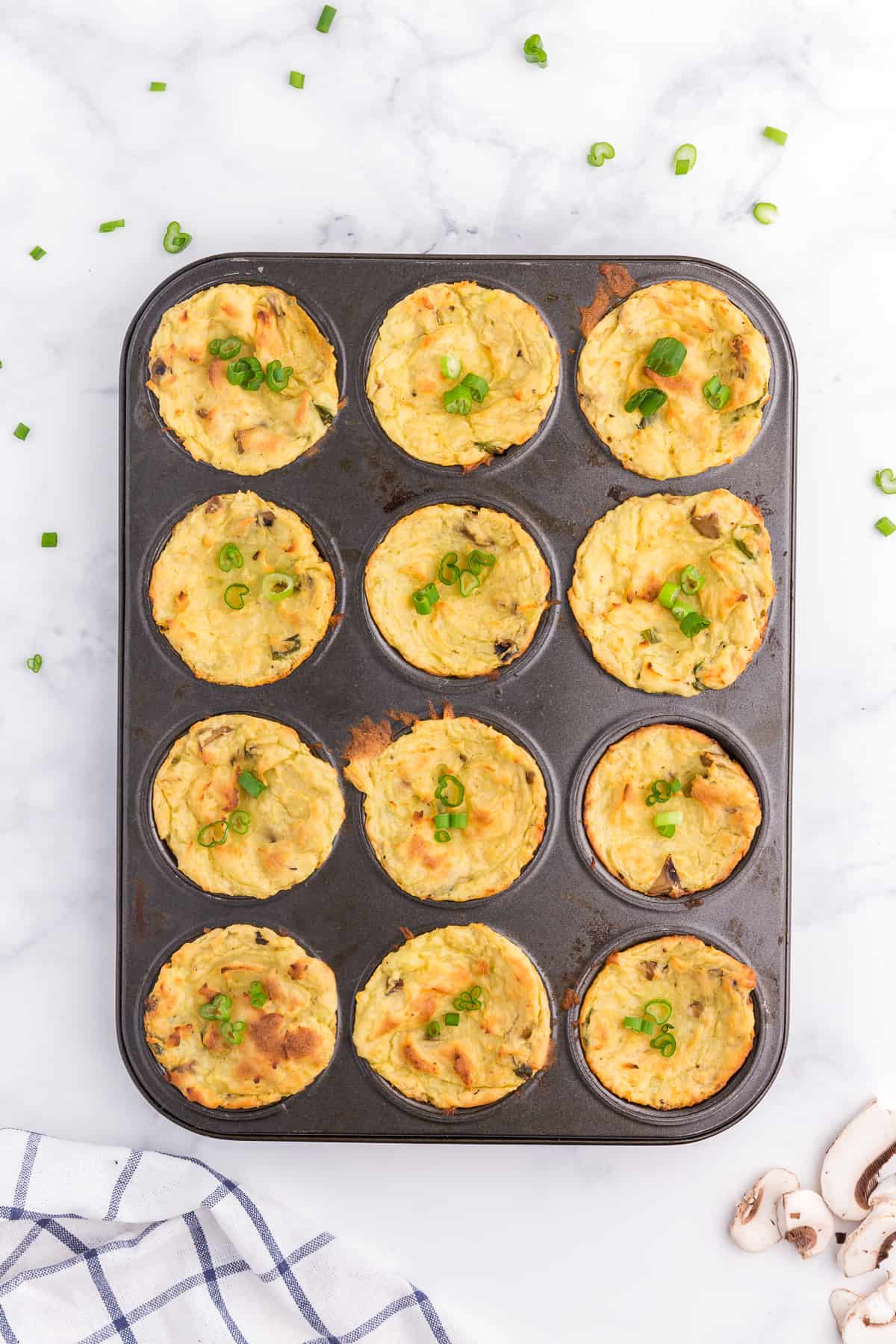 Muffin Tin Mashed Potatoes - Perfect for dinner parties! These loaded mashed potatoes are baked like savory cupcakes with mushrooms and green onions. The best way to use up leftover mashed potatoes!