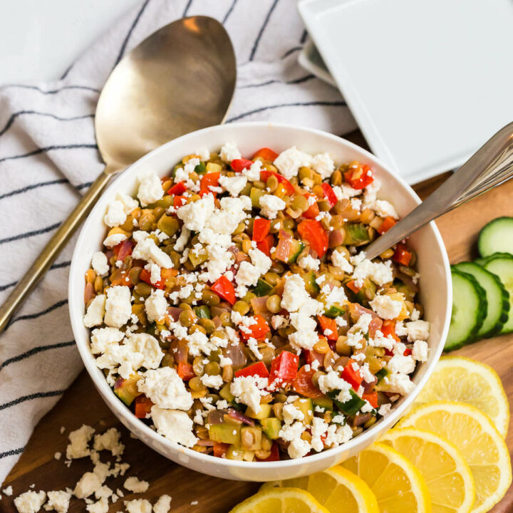 Warm lentil salad in a bowl with a spoon.