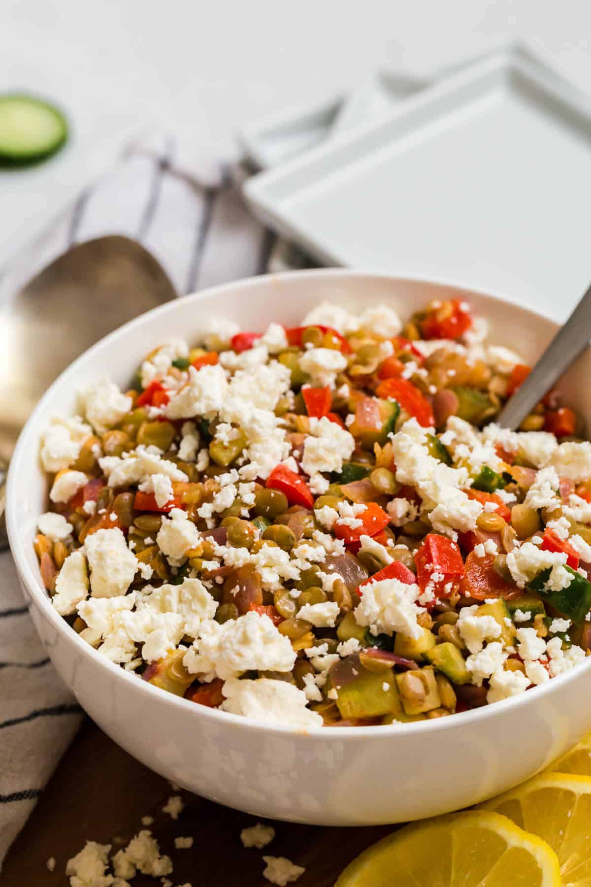 Warm lentil salad in a bowl with a spoon.