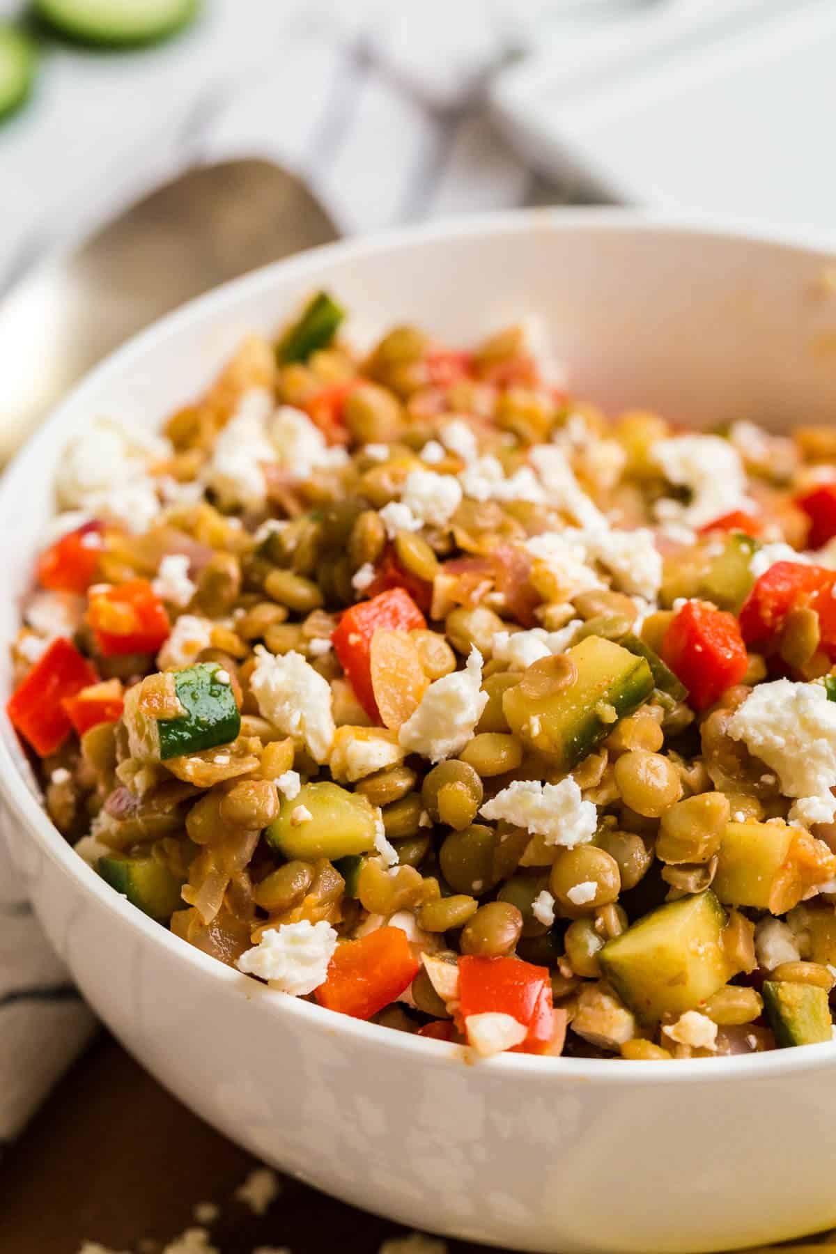 Warm lentil salad in a white bowl.