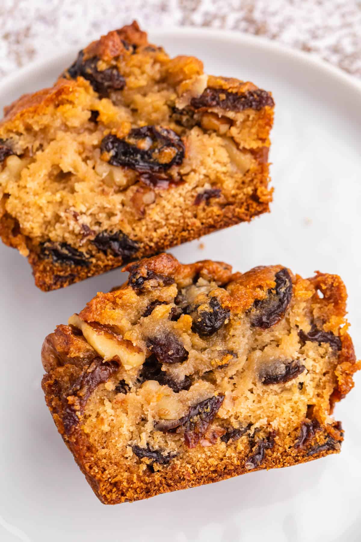 A butter tart muffin cut in half on a plate.