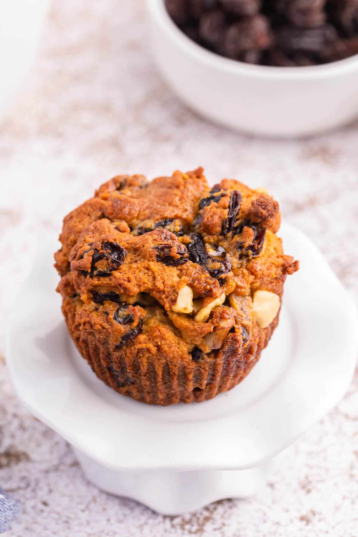 A butter tart muffin on a white cupcake stand.