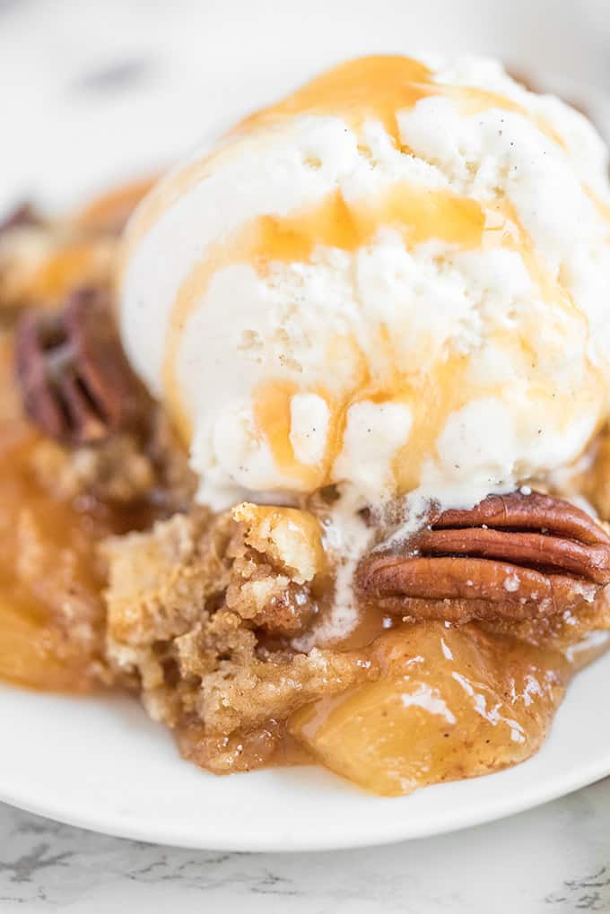 Caramel Apple Dump Cake - One of the easiest cake recipes you will find! Made with butter pecan cake mix, caramel sundae sauce, apple pie filling and pecans.