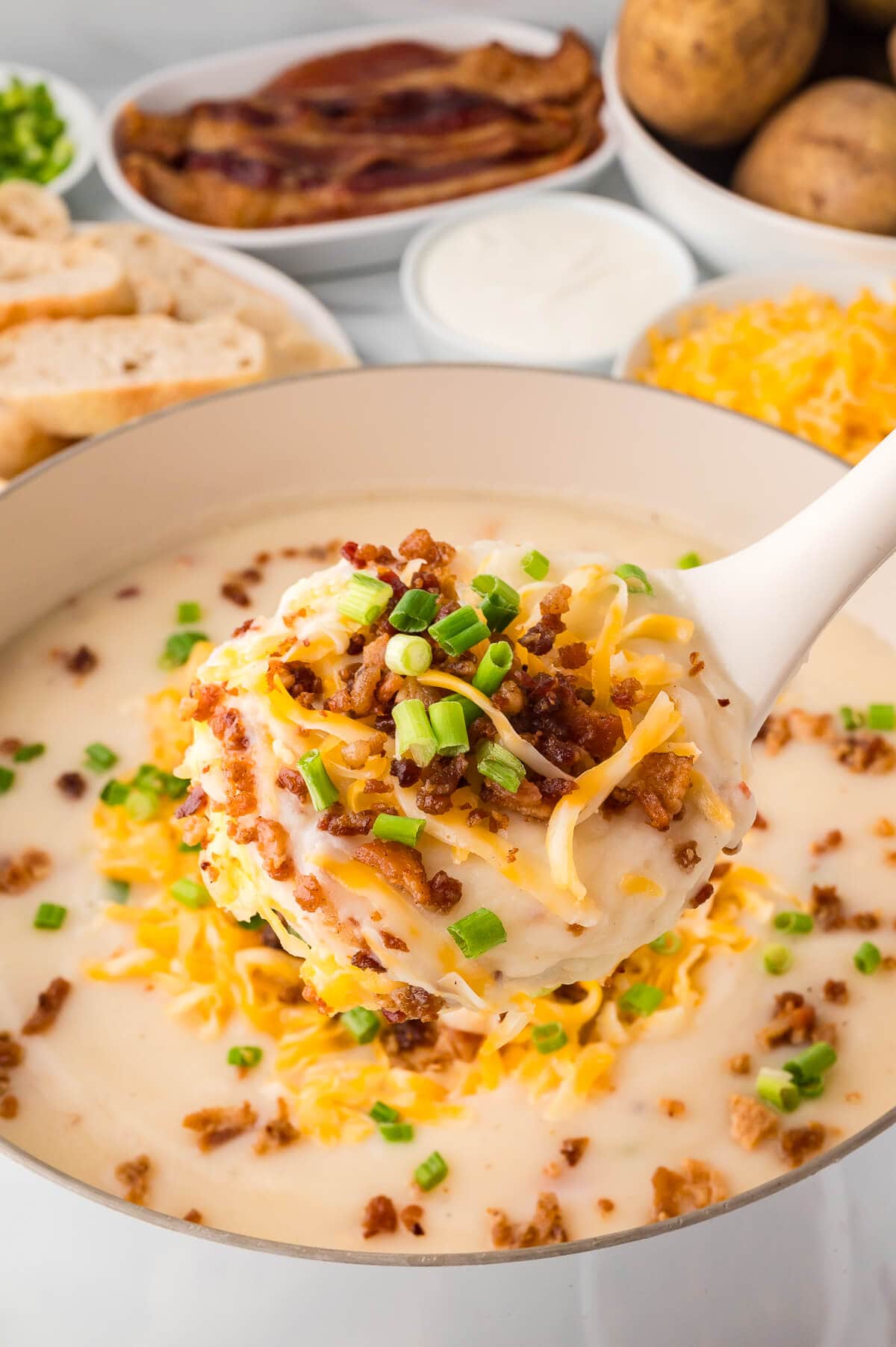 The soup in a ladle over a pot.