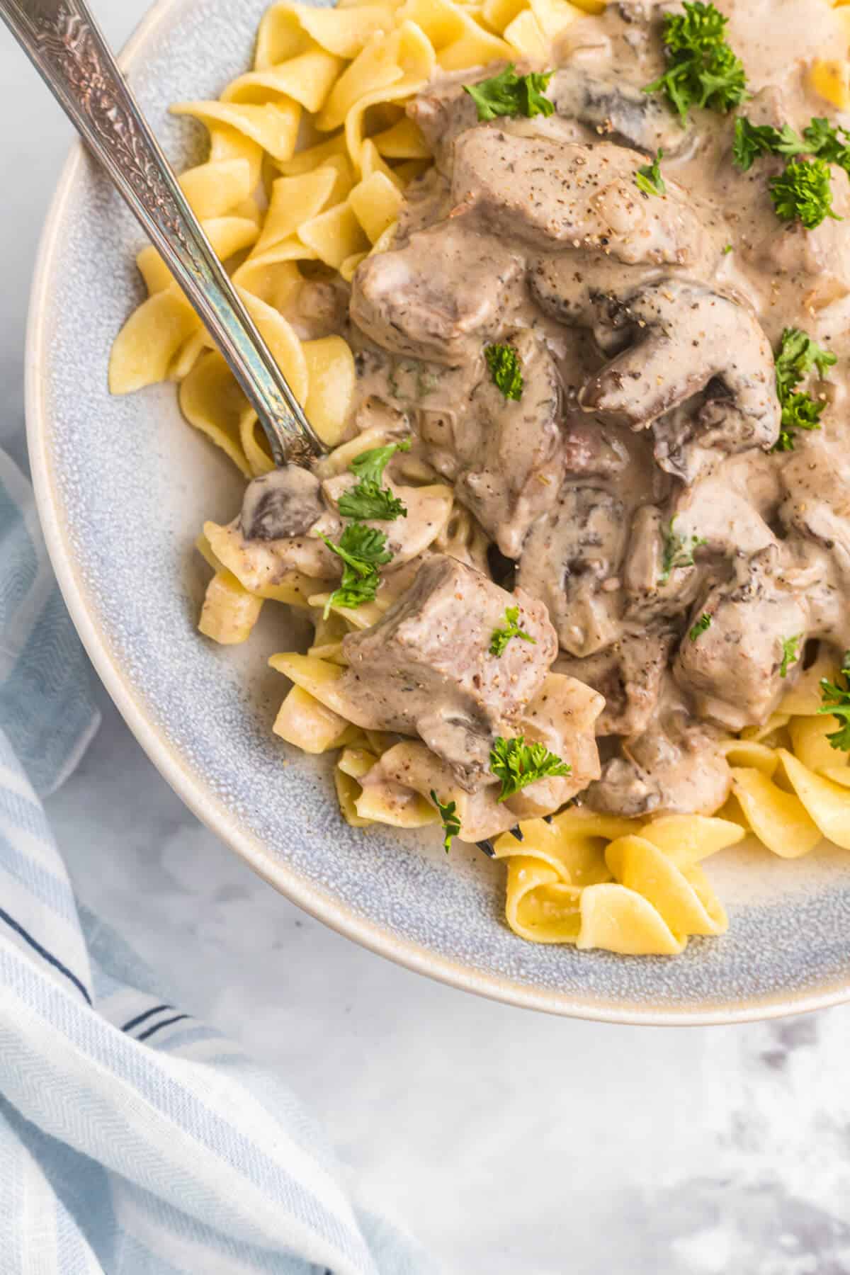 A plate of beef stroganoff with a fork.