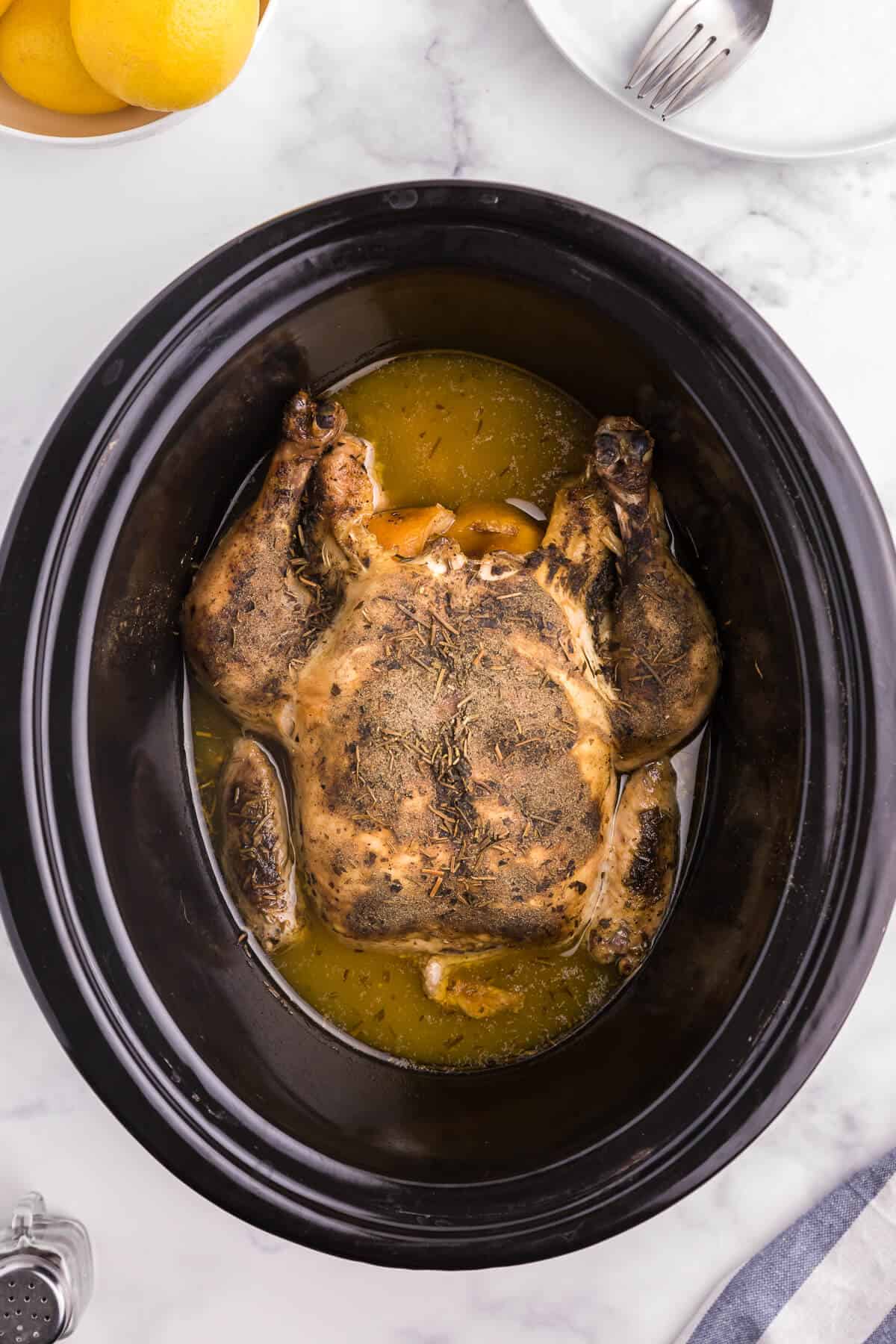 Lemon Herb Slow Cooker Chicken - Roast a whole chicken in your Crockpot! This easy chicken recipe is so much juicier with lemon juice and a succulent herb blend.