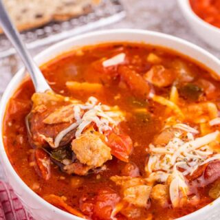 Pizza soup in a bowl with a spoon.