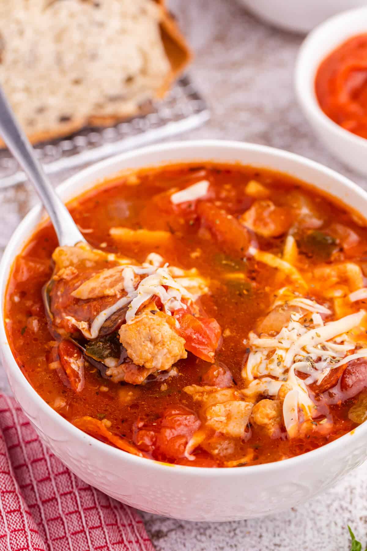 Pizza soup in a bowl with a spoon.