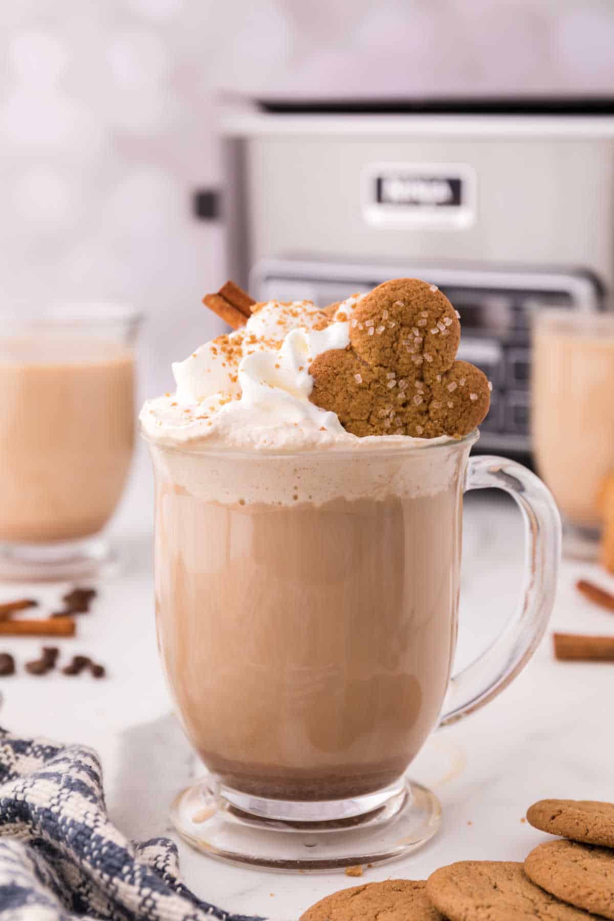 Gingerbread latte with whipped cream on top and a cookie.