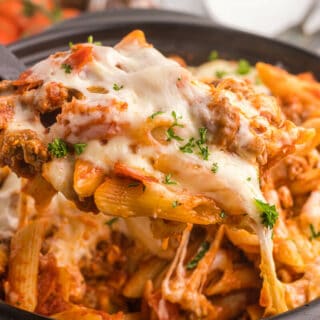 Slow cooker pizza pasta with a serving spoon.