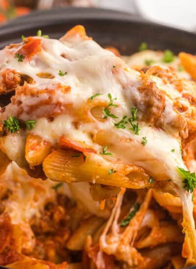 Slow cooker pizza pasta with a serving spoon.