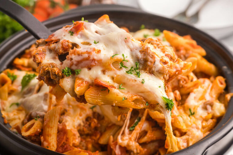 Slow cooker pizza pasta with a serving spoon.