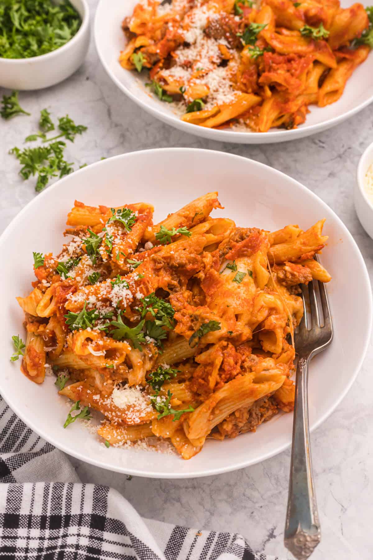 Slow cooker pizza pasta in a pasta bowl with a fork.