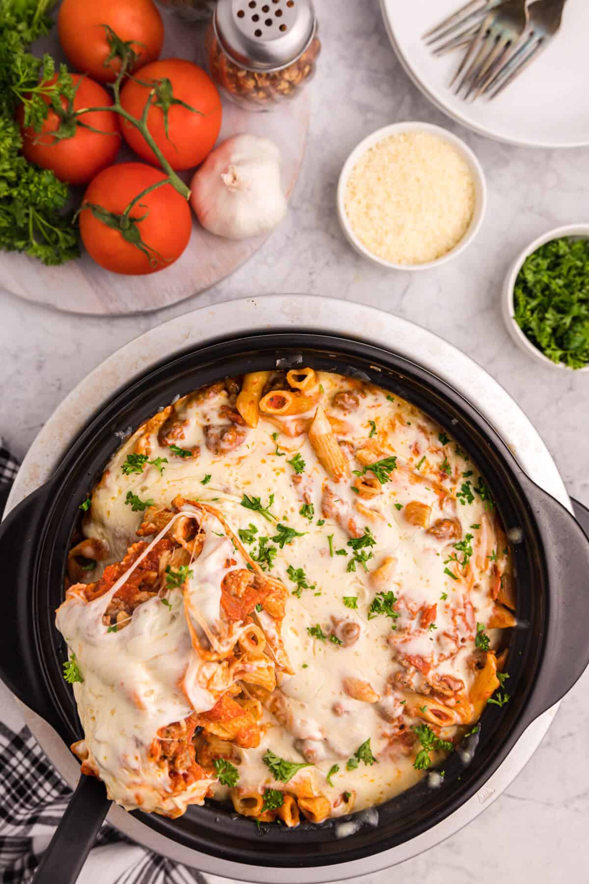 Slow cooker pizza pasta with a serving spoon in the crockpot.