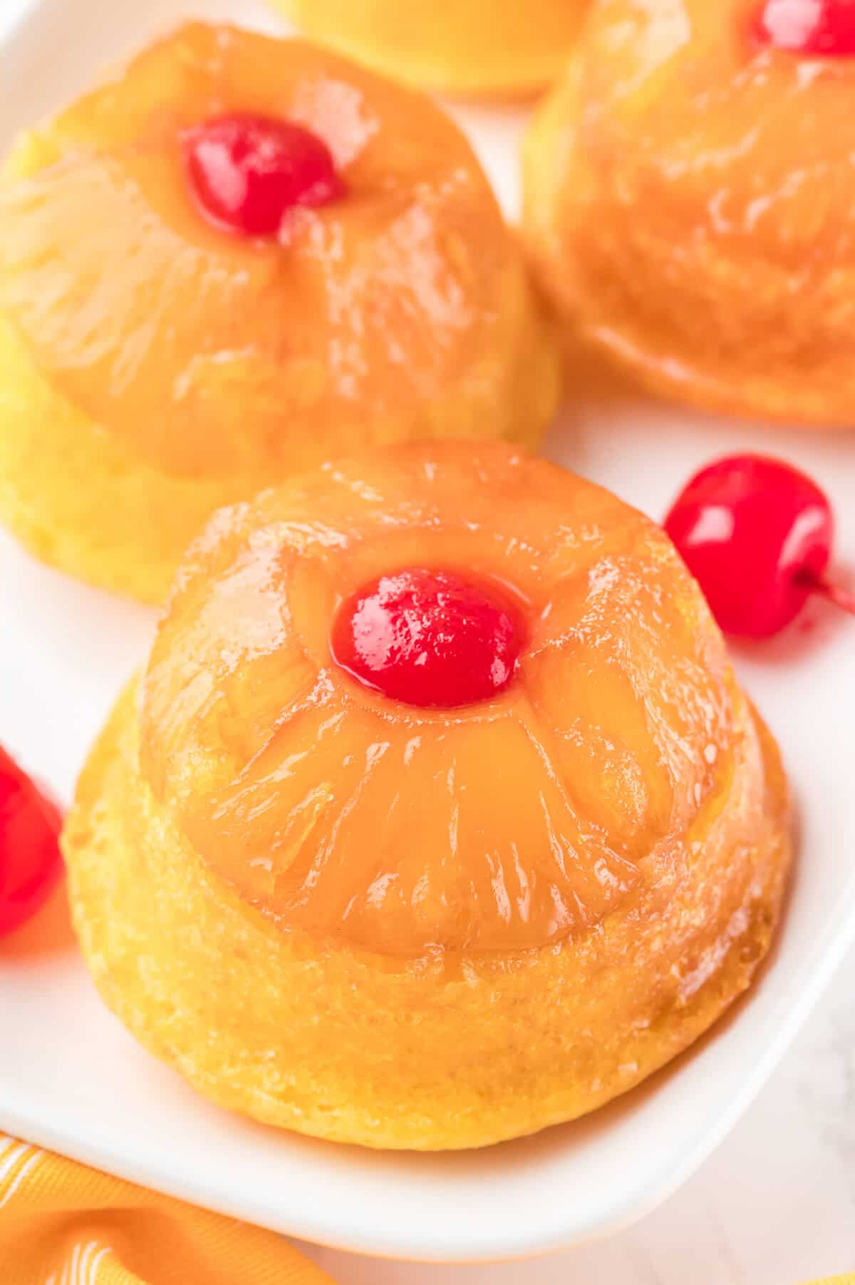 Pineapple upside down cupcakes on a platter.